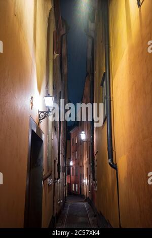Ein Vertikalbild einer schmalen Gasse in Gamla Stan, Stockholm, Schwedens Altstadt, mit bunten Gebäuden aus dem 17. Und 18. Jahrhundert und Kopfsteinpflasterstraßen. Stockfoto