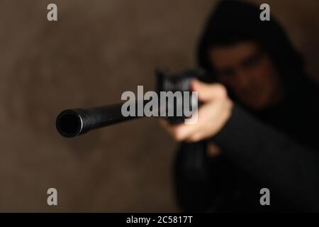 Der Mann in der Haube hält die Waffe. Selektiver Fokus. Raub Stockfoto