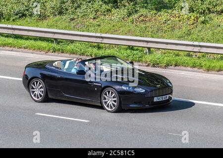 2005 schwarz Aston Martin DB9 DB 9 5.9 V12 Touchtronic (Seq) 2dr Coupe 5.9; Fahrzeuge mit Verkehrsbehinderungen, privates Nummernschild, personalisiert, geschätzt, datierlos zugelassen, DVLA-Kennzeichen auf Autofahrern auf britischen Straßen, Motoren, Autofahren auf dem Autobahnnetz der M6. Stockfoto