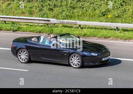 2005 schwarz Aston Martin DB9 DB 9 5.9 V12 Touchtronic (Seq) 2dr Coupe 5.9; Fahrzeuge mit Verkehrsbehinderungen, privates Nummernschild, personalisiert, geschätzt, datierlos zugelassen, DVLA-Kennzeichen auf Autofahrern auf britischen Straßen, Motoren, Autofahren auf dem Autobahnnetz der M6. Stockfoto