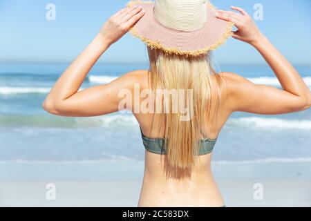 Rückansicht einer Frau mit Hut am Strand Stockfoto