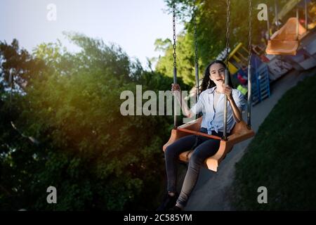 Happy Kind Teenager Mädchen Reiten Kette Karussell Schaukel im Vergnügungspark Stockfoto