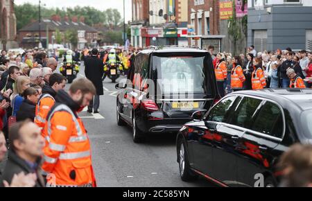 Mitglieder des Community Rescue Service (in hallo-vis Jacken) bilden eine Ehrenwache, als der Leichenfalle des 14-jährigen Noah Donohoe seine Schule verlässt, St. Malachys College in Belfast, wo er für kurze Zeit neben seinen Klassenkameraden pausierte, Nach seinem privaten Trauerdienst in der St. Patrick's Church. Stockfoto