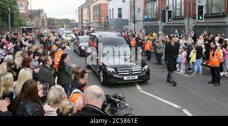 Die Menschen säumen die Straßen, als die Leichenhalle von Noah Donohoe in das Saint Malachy's College in Belfast eindringt, wo der Teenager nach seinem privaten Trauerdienst in der Saint Patrick's Church zur Schule ging. Stockfoto