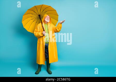 Volle Länge Körpergröße Ansicht seiner er nett unzufrieden genervt genervt grauhaarigen Mann trägt Topcoat Überprüfung halten Tropfen auf der Handfläche isoliert über Stockfoto