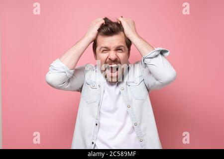 Junger, hübscher Geschäftsmann mit Bart und Händen auf dem Kopf Stockfoto