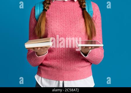 Modernes Gadget und Buch. Teen Mädchen hält Buch und digitale Tablette in den Händen Stockfoto