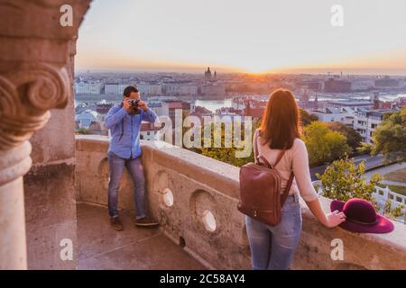 Junge Paare fotografieren sich am Aussichtspunkt von der Fischerbastei in Budapest bei Sonnenaufgang. Stockfoto