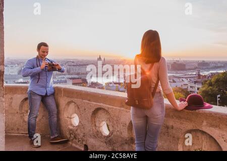 Junge Paare fotografieren sich am Aussichtspunkt von der Fischerbastei in Budapest bei Sonnenaufgang. Stockfoto