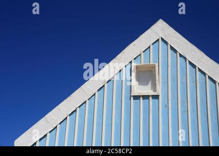 Portugal, Caparica Coast, Atlantic Coast Beach bei Lissabon - blau-weiß-Bonbon-gestreifte Strandhütten-Details vor einem klaren blauen Himmel. (Platz für Kopie) Stockfoto