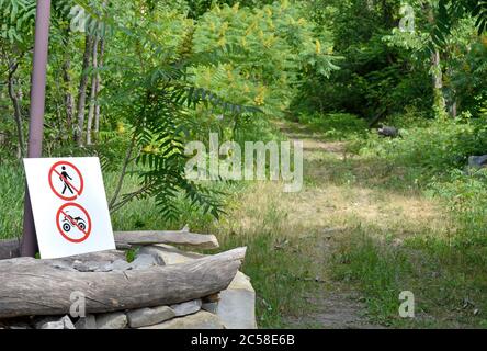 Ein Schild zeigt keine Fuß oder Motocross auf dem Weg. Die Natur braucht eine Pause. Stockfoto