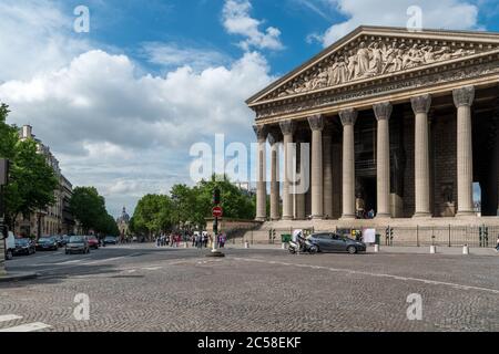 Die L'église de la Madeleine mit Touristen im Vordergrund und die Église Saint-Augustin im Hintergrund. Stockfoto