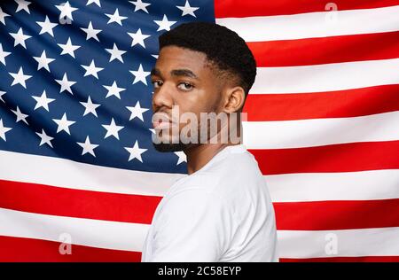 Schwarze Leben Sind Wichtig. Ernster afrikanischer amerikanischer Mann posiert über USA Flagge Hintergrund Stockfoto