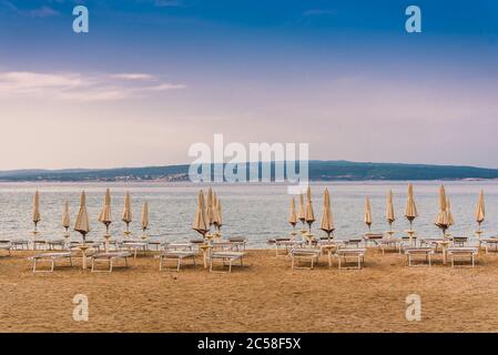 Sonnenschirme am leeren Strand von Crikvenica am frühen Morgen. Crikvenica ist ein beliebter Ferienort in Kroatien Stockfoto