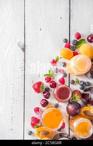 Auswahl an Beeren und Obstkonfitüren. Set aus verschiedenen saisonalen Sommer-Beeren und Obstmarmelade, Marmelade und Konfitüre. Weißer Holzhintergrund Kopie SPAC Stockfoto