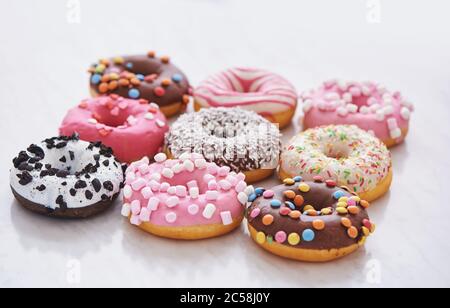 Mix aus bunten süßen Donuts mit Streuseln. Nahaufnahme Stockfoto