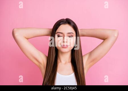 Nahaufnahme Foto von ziemlich ruhig Dame erfreut gute Laune Augen geschlossen Nappen denken Arme hinter dem Kopf tragen lässig weiß Singlet isoliert pastellrosa Stockfoto