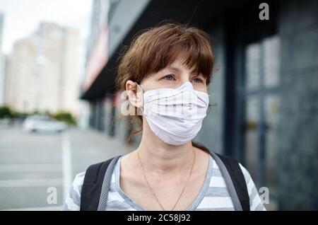 Frau, die hygienische Maske trägt, um das Coronavirus zu verhindern. Menschen in Masken den Ausbruch des neuartigen Corona-Virus (2019-nCoV) in Europa Stockfoto