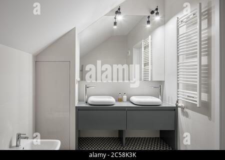 Weißes, Dachgeschoss-Badezimmer mit zwei Waschbecken und großem Spiegel Stockfoto