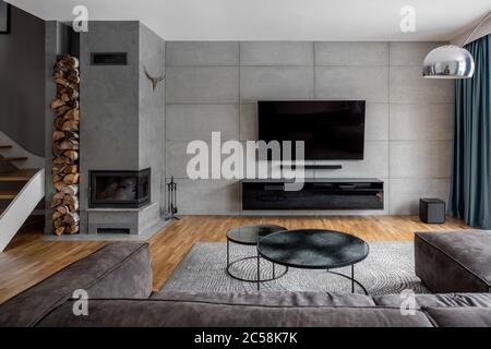 TV Wohnzimmer mit Zementwand und Kamin an der Wand montiert Stockfoto