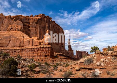 Landschaftlich reizvolle Aussicht auf monolithische Sandsteinfelsen entlang des Park Avenue Trail mit Turm von Babel in der Ferne, Arches National Park, Moab, Stockfoto