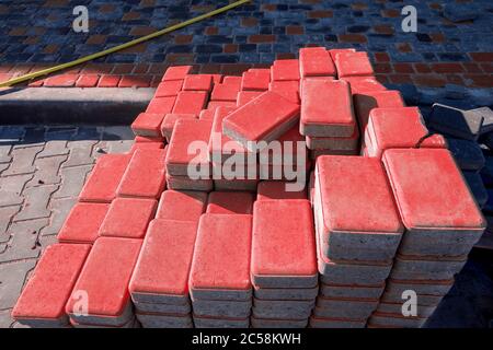 Neue rote Pflasterplatten in einem Stapel auf einem anderen an einem sonnigen Tag gefaltet, Nahaufnahme. Stockfoto
