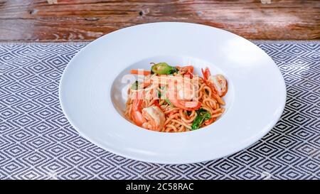 Die Spaghetti würzigen Garnelen in einem weißen Teller auf der Tischdecke. Stockfoto