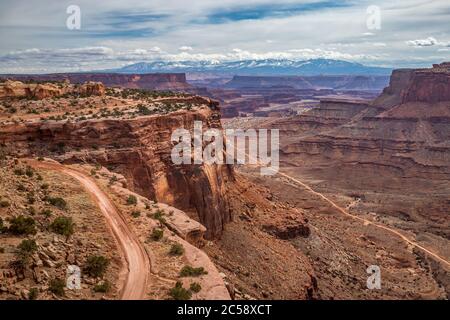 Spektakuläre Aussicht auf den rauen Shafer Trail, der sich an einem bewölkten Tag in den Shafer Canyon schlängelt, Shafer Canyon Overlook, Island im Sky District, Canyon Stockfoto