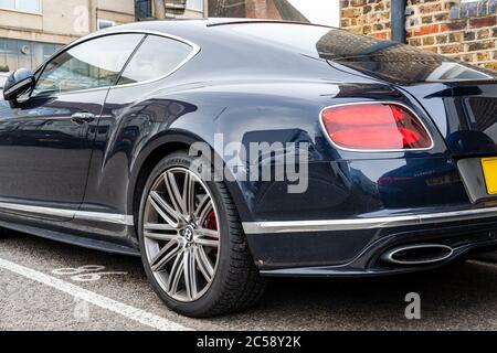 Flacher Fokus, isolierte Ansicht eines berühmten, britischen Luxusauto-Logos auf dem Kofferraum eines Sportwagens. In einem privaten Parkplatz. Stockfoto