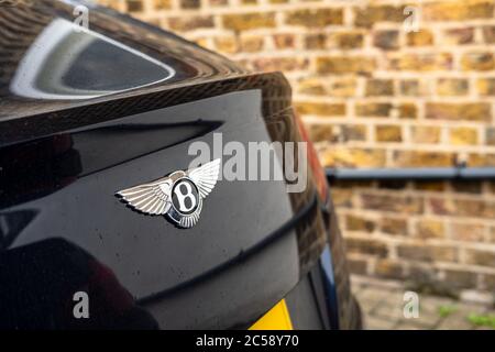 Flacher Fokus, isolierte Ansicht eines berühmten, britischen Luxusauto-Logos auf dem Kofferraum eines Sportwagens. In einem privaten Parkplatz. Stockfoto
