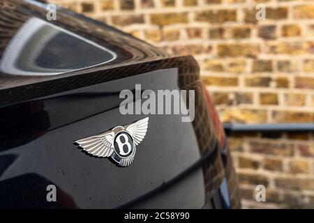 Flacher Fokus, isolierte Ansicht eines berühmten, britischen Luxusauto-Logos auf dem Kofferraum eines Sportwagens. In einem privaten Parkplatz. Stockfoto