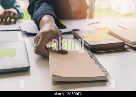 Nahaufnahme der Hände eines Mannes, der im Büro ein Notebook abholt. Stockfoto