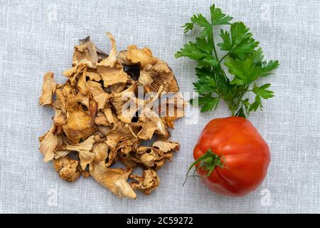 Pilze, Tomaten und Grüns auf einer Serviette aus Leinwand. Kulinarisches Layout Stockfoto