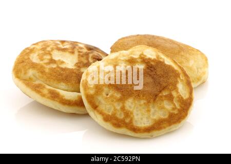 Frisch gebackene traditionelle holländische Mini-Pfannkuchen genannt "poffertjes" mit Puderzucker auf weißem Hintergrund Stockfoto