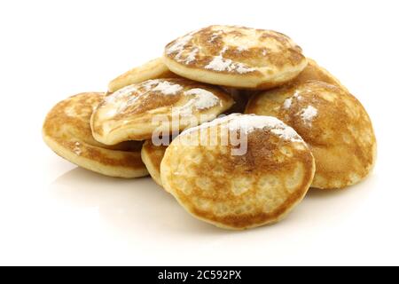 Frisch gebackene traditionelle holländische Mini-Pfannkuchen genannt "poffertjes" mit Puderzucker auf weißem Hintergrund Stockfoto