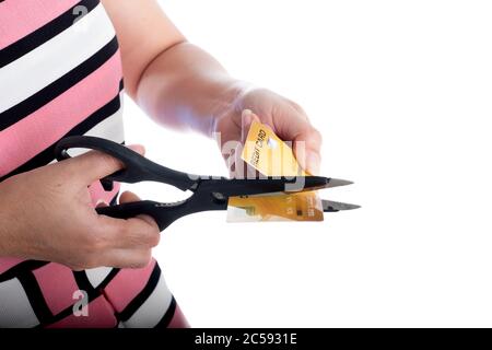 Nahaufnahme junge Frau Hand Schneiden eine Kreditkarte mit Schere, um zu stoppen Ausgaben für den Einkauf auf dem weißen Hintergrund Stockfoto
