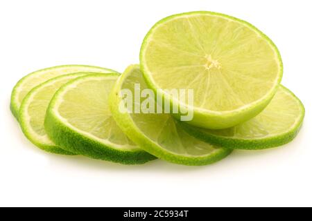 Frische Limettenfrüchte und einige dünne Scheiben auf weißem Hintergrund Stockfoto