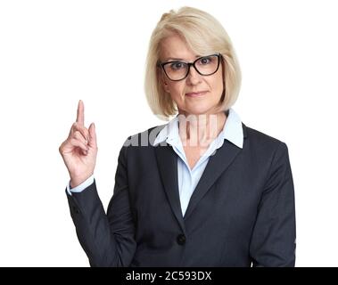 Geschäftsfrau mittleren Alters mit Brille und schwarzer Jacke, die ihren Finger nach oben zeigt. Isoliert auf Weiß Stockfoto
