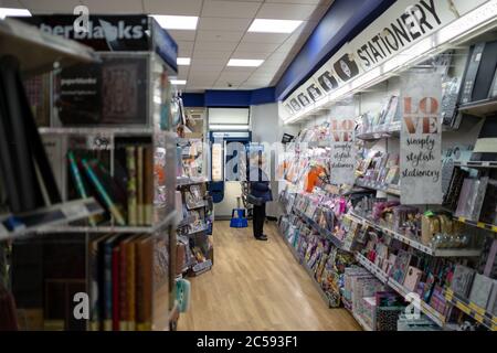 Frau sah, wie sie die stationäre Sektion eines bekannten britischen Magazins und stationären Verkäufers durchstöberte. Stockfoto