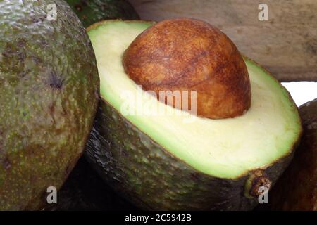 Frische und reife Avocado's in einer Holzkiste auf weißem Hintergrund Stockfoto