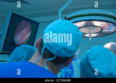Nahaufnahme Team von Praktikanten Studenten Blick auf den Monitor beobachten eine Operation für endoskopische laparoskopische Chirurgie. In einem sterilen Operationssaal. Stockfoto