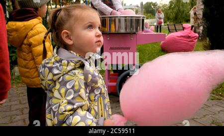 Mädchen essen Zuckerwatte im Park Stockfoto