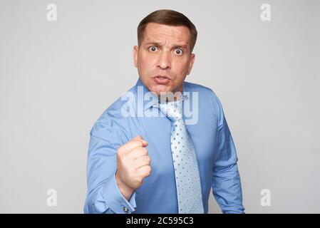 Wütend Geschäftsmann isoliert auf grauem Hintergrund Stockfoto