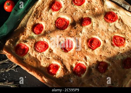 Italienische köstliche Focaccia Rechteck Brot mit in Scheiben geschnittenen Kirschtomaten Stockfoto