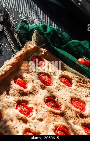 Focaccia homemaade italienisches Brot gebacken mit in Scheiben geschnittenen Kirschtomaten, Meersalz und Rosmarinkräutern Stockfoto