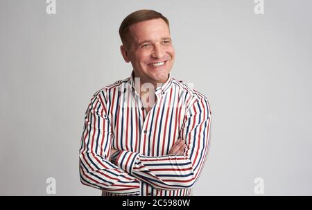Happy 40 Jahre Mann im gestreiften Hemd schaut weg. Isoliert Stockfoto