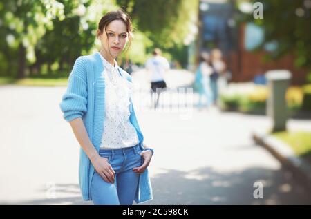 Porträt einer selbstbewussten Frau, die auf dem Stadtpark steht. Hübsches Mädchen trägt Strickpullover Stockfoto