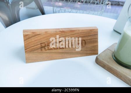 Ein Tag der Reservierung, der auf dem Tisch platziert wird. Reserviertes Logo in einem Restaurant oder Sommerterrasse des Cafés. Stockfoto