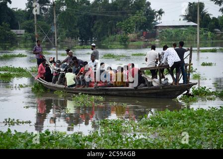 Morigaon, Assam, Indien. Juli 2020. Dorfbewohner überqueren ein überflutetes Gebiet auf einem Boot, im Dorf Buraburi im Morigaon Bezirk von Assam. Kredit: David Talukdar/ZUMA Wire/Alamy Live Nachrichten Stockfoto