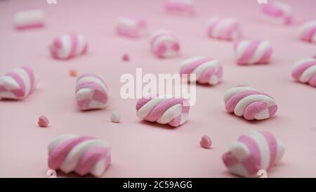 Viele rosa Marshmallows auf einem rosa Hintergrund und Herz dazwischen. Valentinstag. Stockfoto